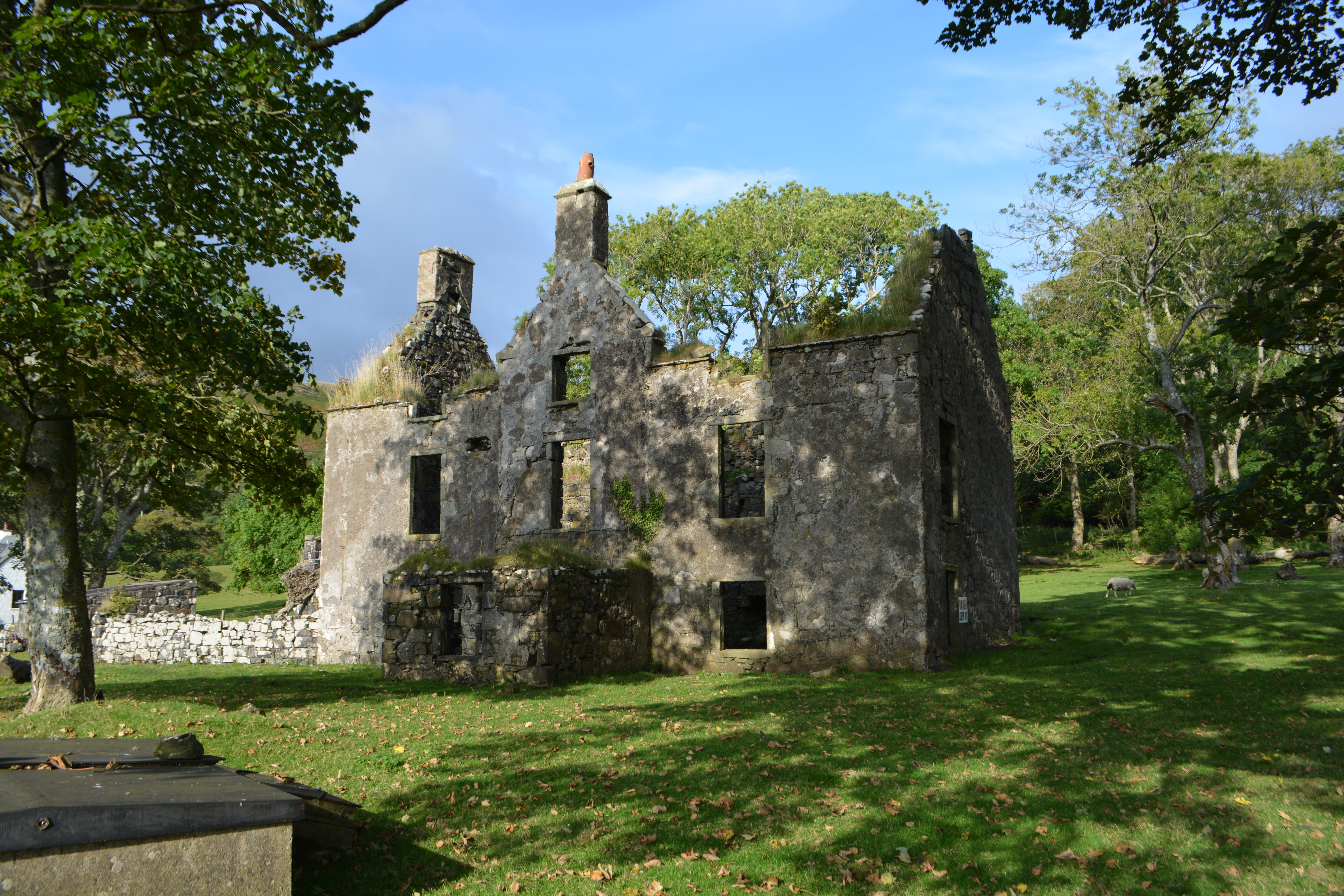 Ruins of a stone building in a grassy field.