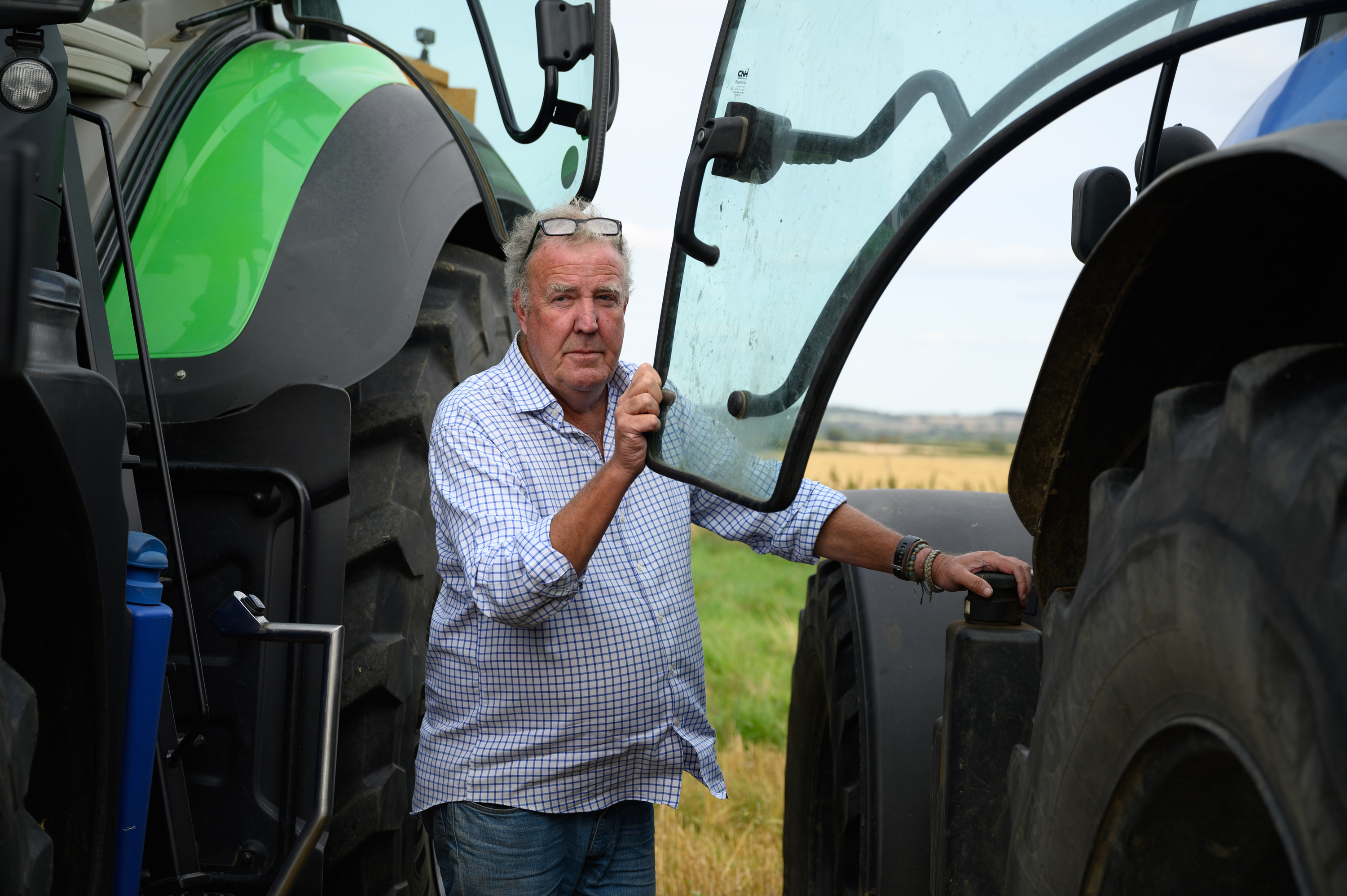 Jeremy Clarkson standing between two tractors.