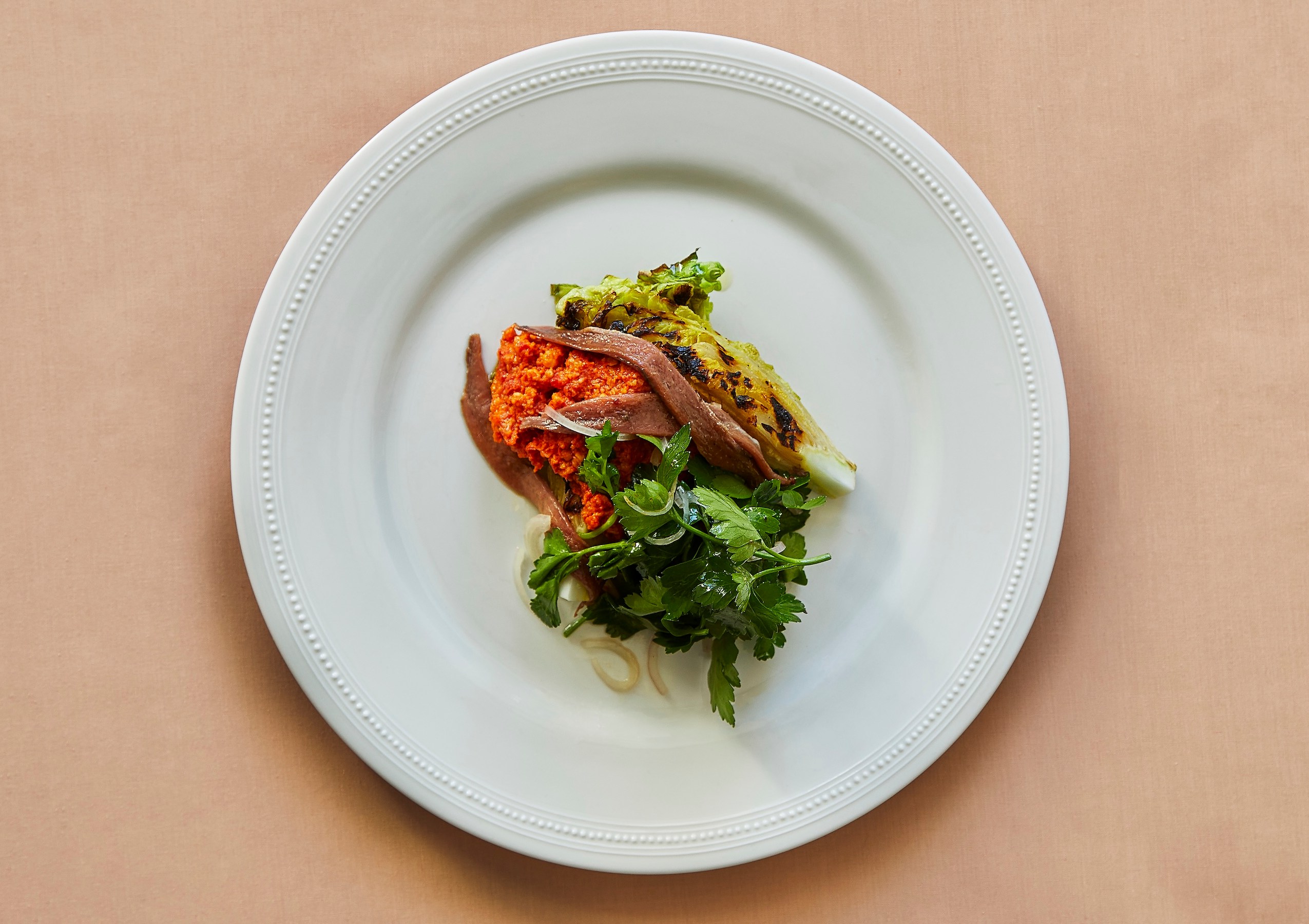 Plate of grilled cabbage, anchovy, and red pepper relish.