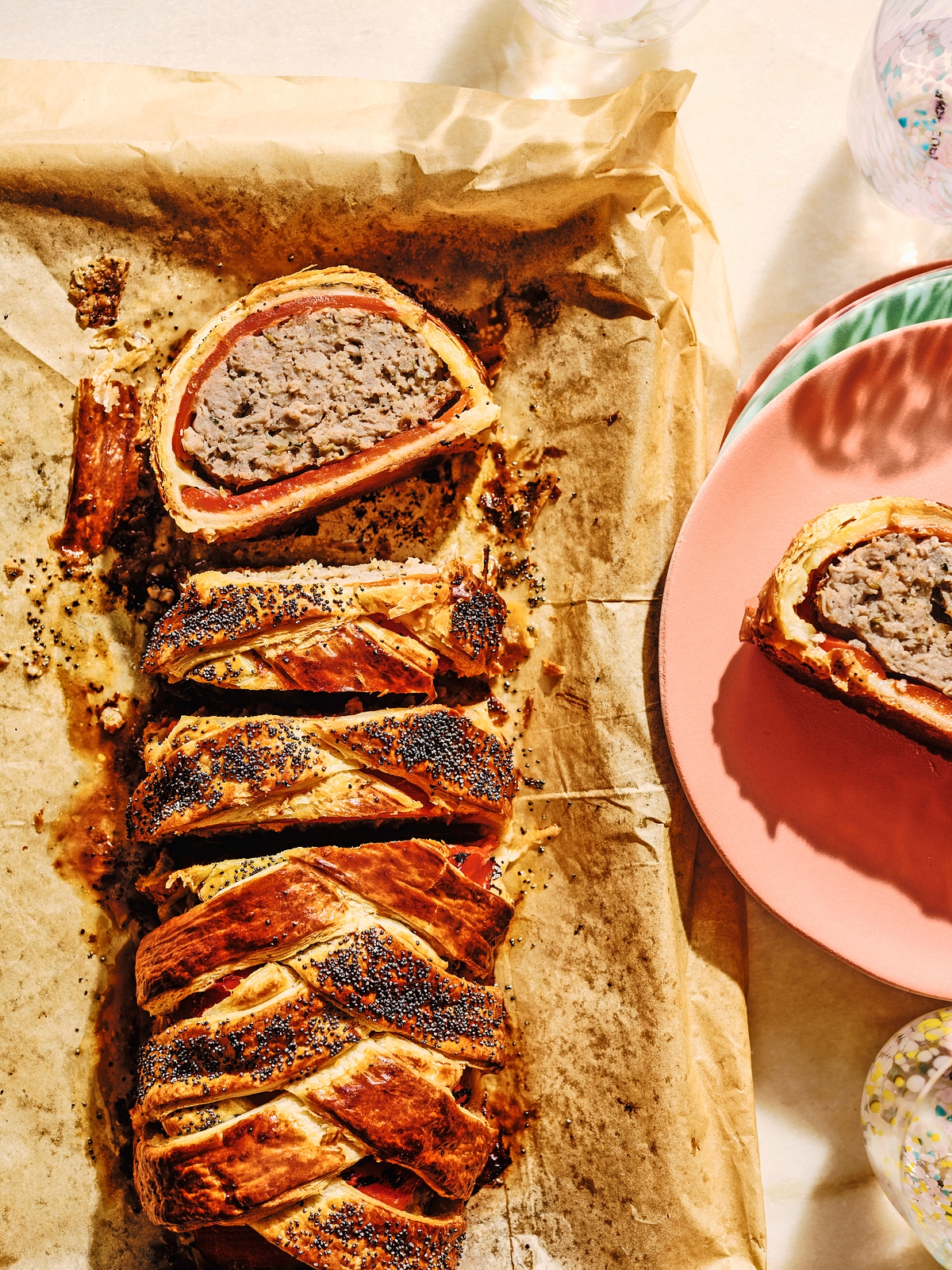 Sausage plait sliced on a baking sheet.