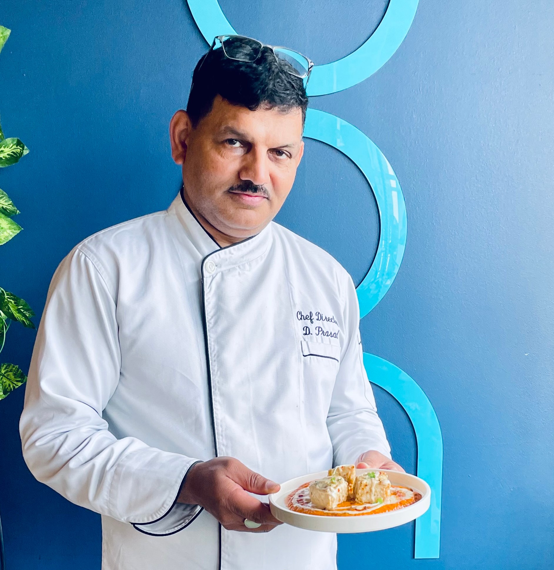 Chef Dhaneshwar Prasad with a beautifully prepared plate of food.