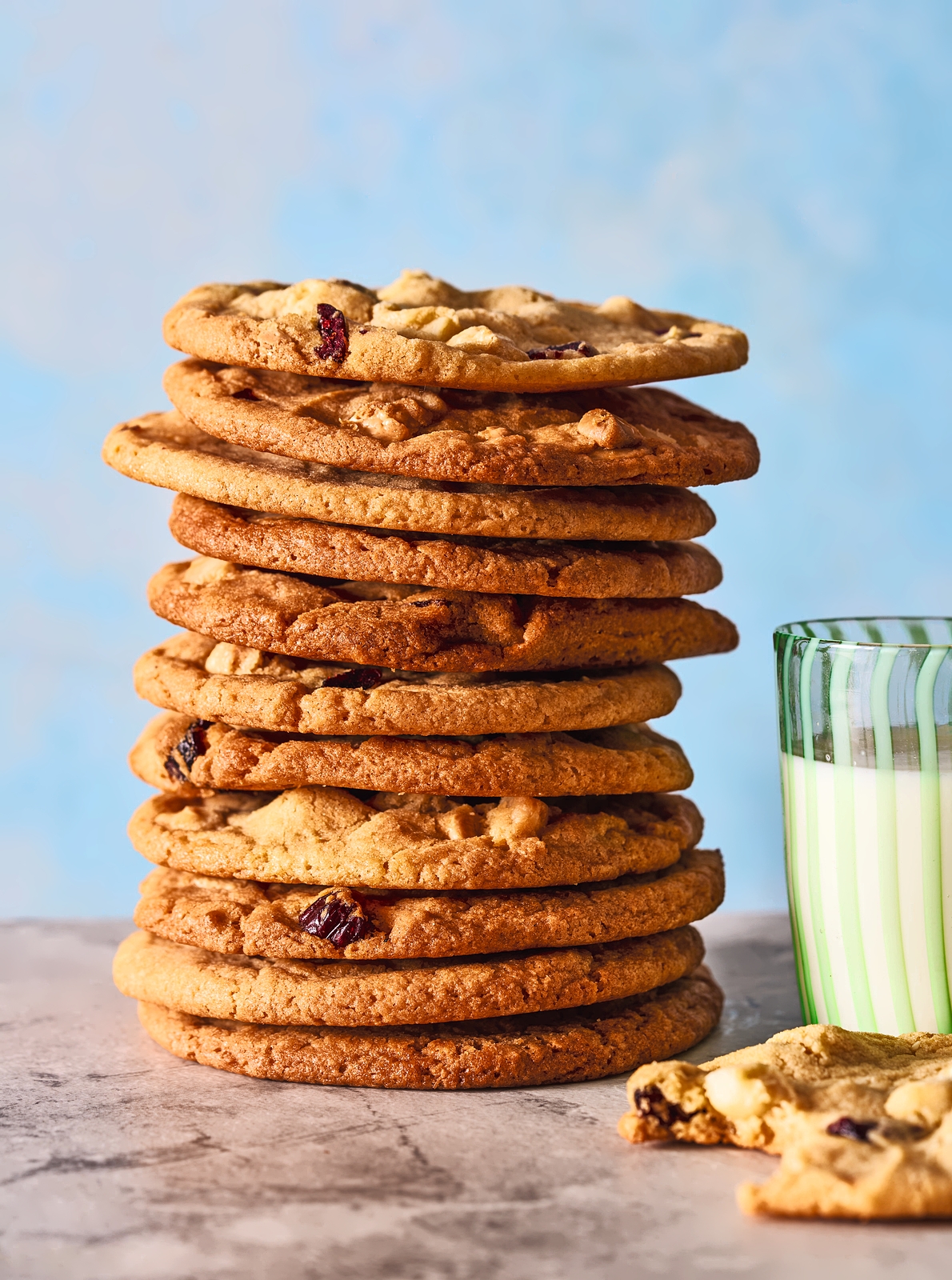 Stack of white chocolate cookies and a glass of milk.